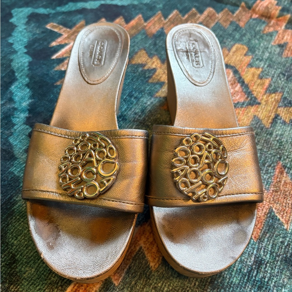 Coach Judith wedge sandals, metallic, cork heel; large signature pendant.